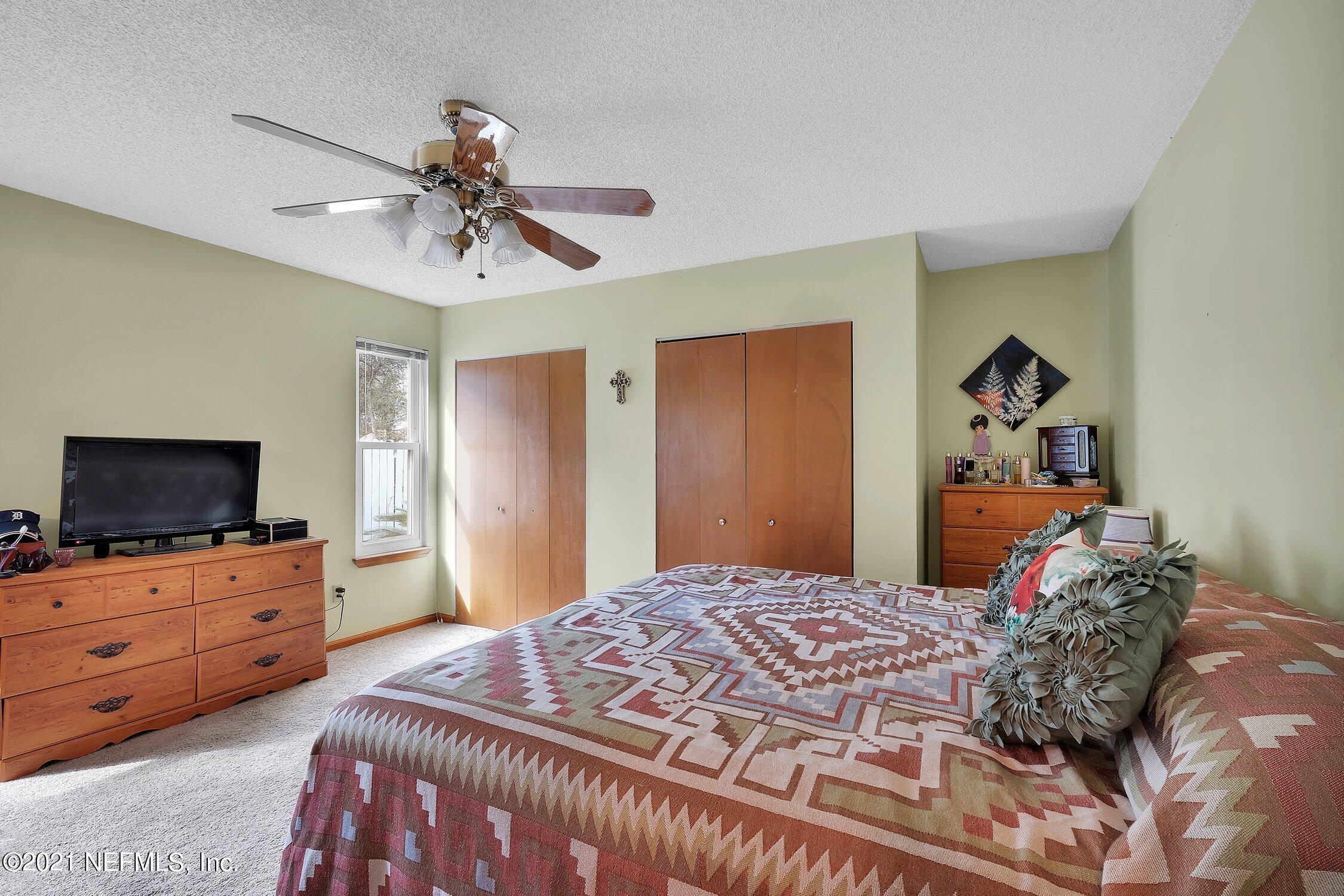 12840 Beaubien Road Jacksonville, FL 32258 - Photo 19 of 25 a bedroom with a bed and a flat screen tv