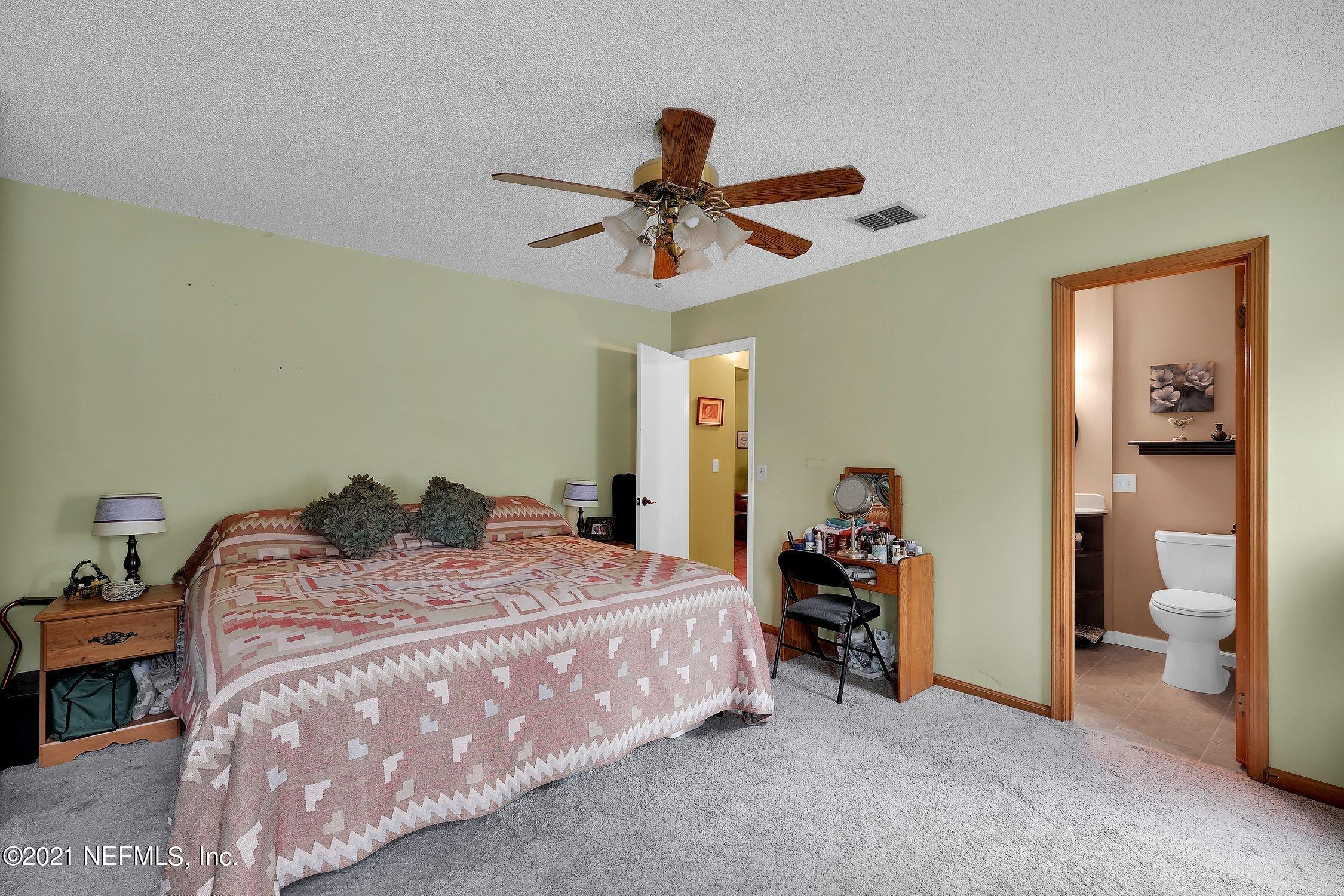 12840 Beaubien Road Jacksonville, FL 32258 - Photo 20 of 25 a bedroom with a bed and a chandelier