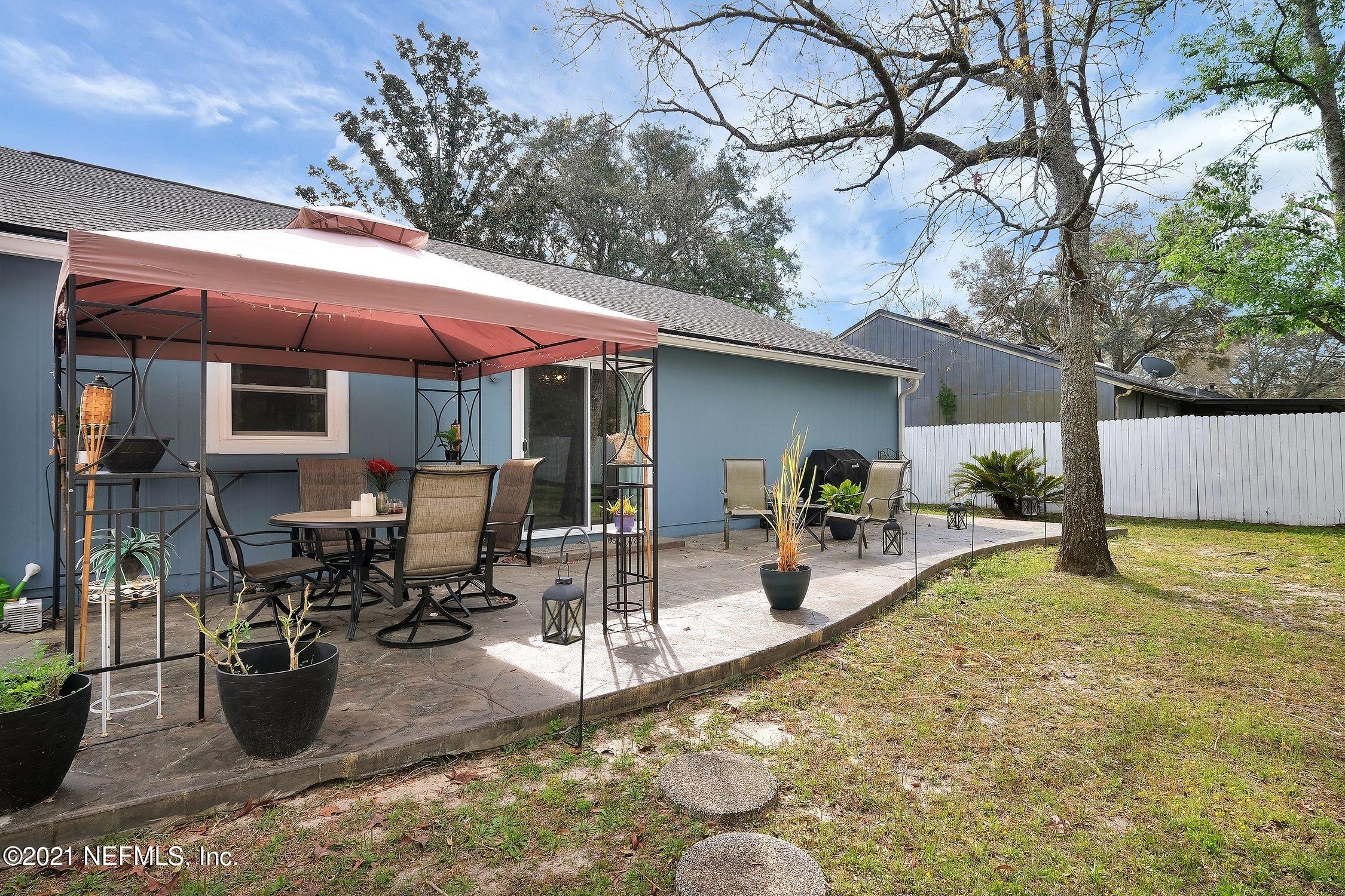 12840 Beaubien Road Jacksonville, FL 32258 - Photo 23 of 25 a view of a backyard with table and chairs potted plants and a large tree