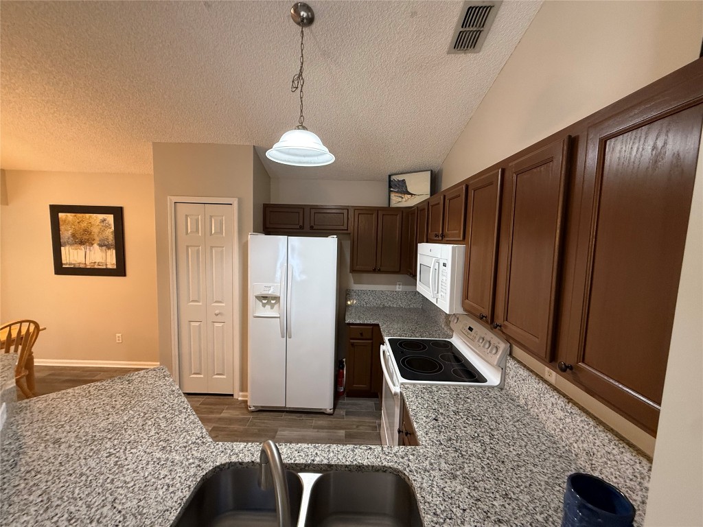 96118 Green Pine Road Yulee, FL 32097 - Photo 7 of 20 a kitchen with stainless steel appliances granite countertop a refrigerator a stove and a sink with wooden floor