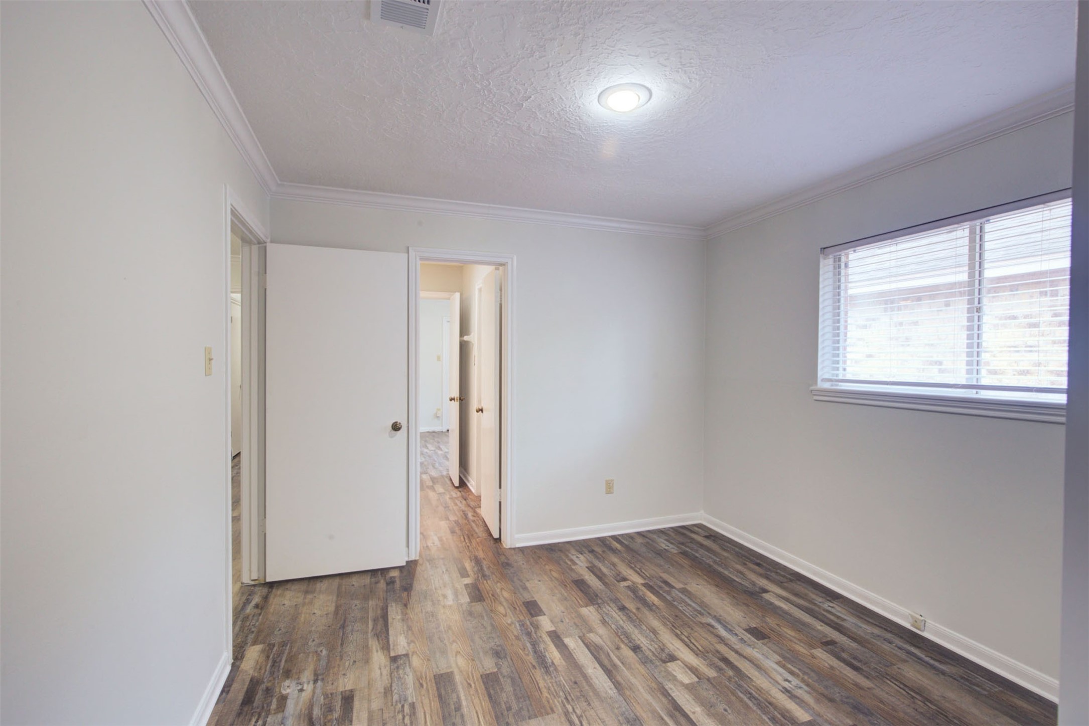 1402 Forest Home Drive Houston, TX 77077 - Photo 22 of 35 an empty room with wooden floor and windows