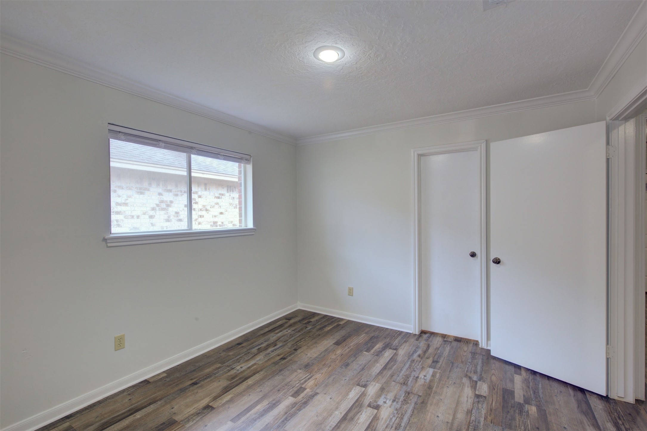 1402 Forest Home Drive Houston, TX 77077 - Photo 25 of 35 an empty room with wooden floor and windows
