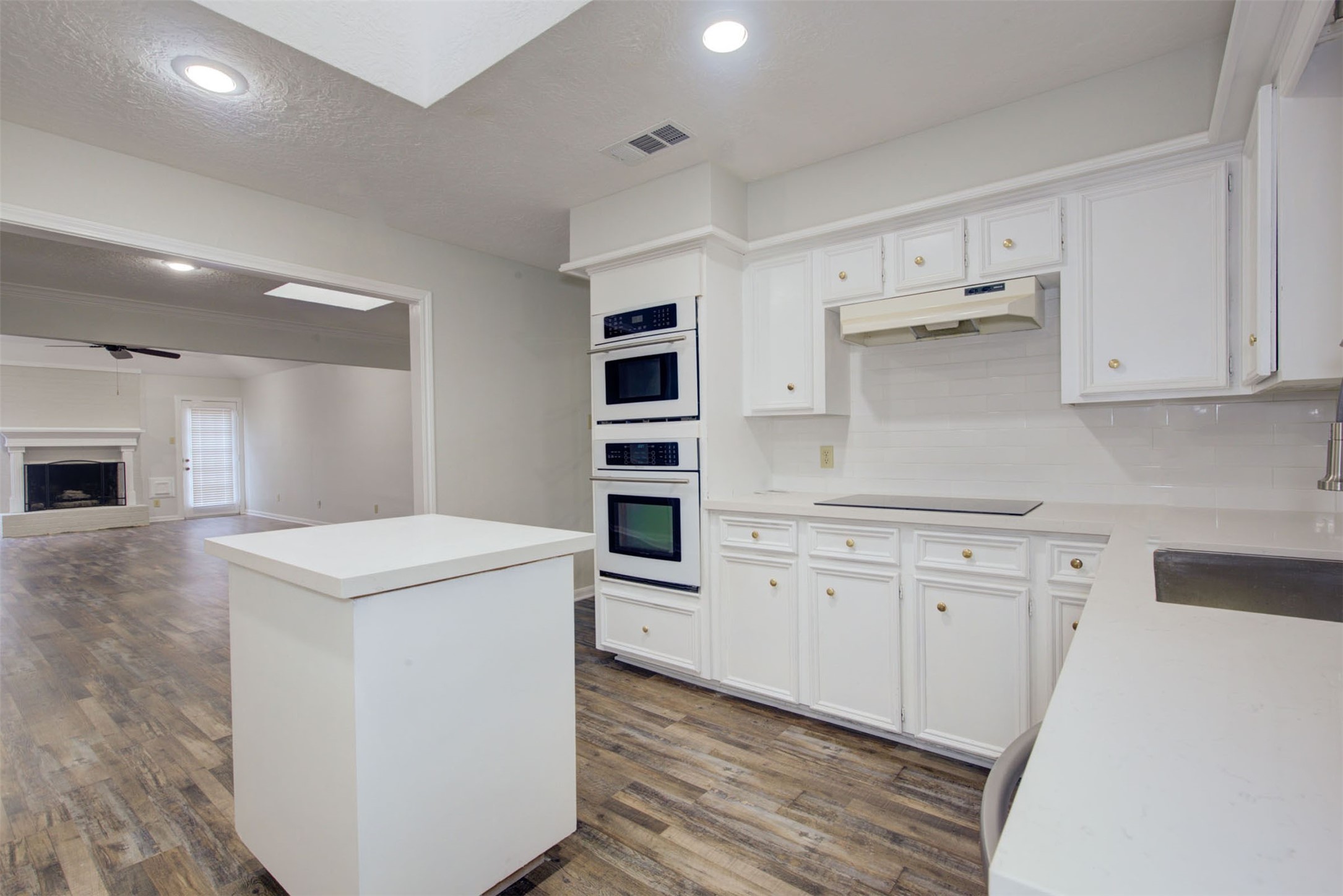 1402 Forest Home Drive Houston, TX 77077 - Photo 9 of 35 a kitchen with stainless steel appliances white cabinets and wooden floors