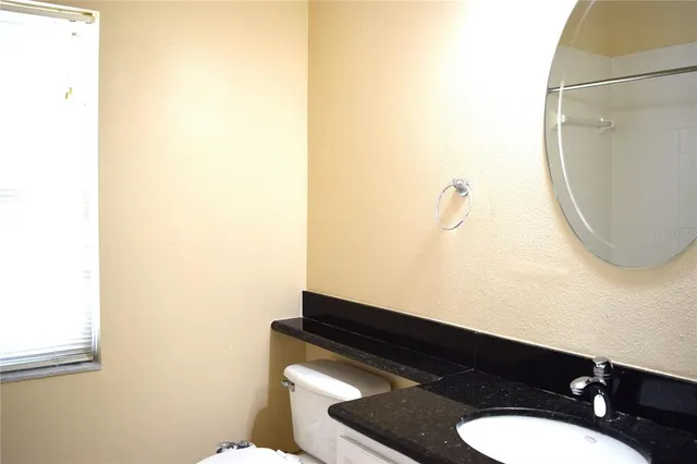 a bathroom with a sink a toilet and a mirror