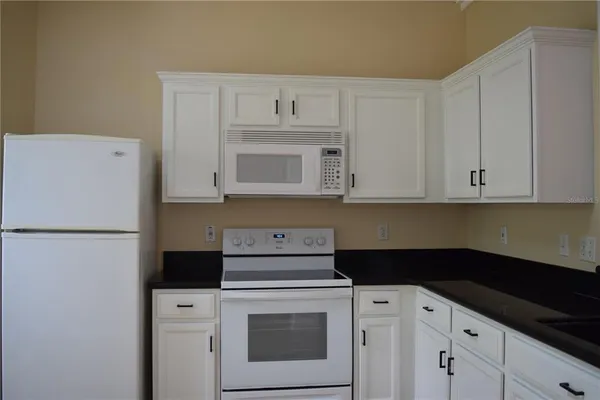 a kitchen with white cabinets and white appliances