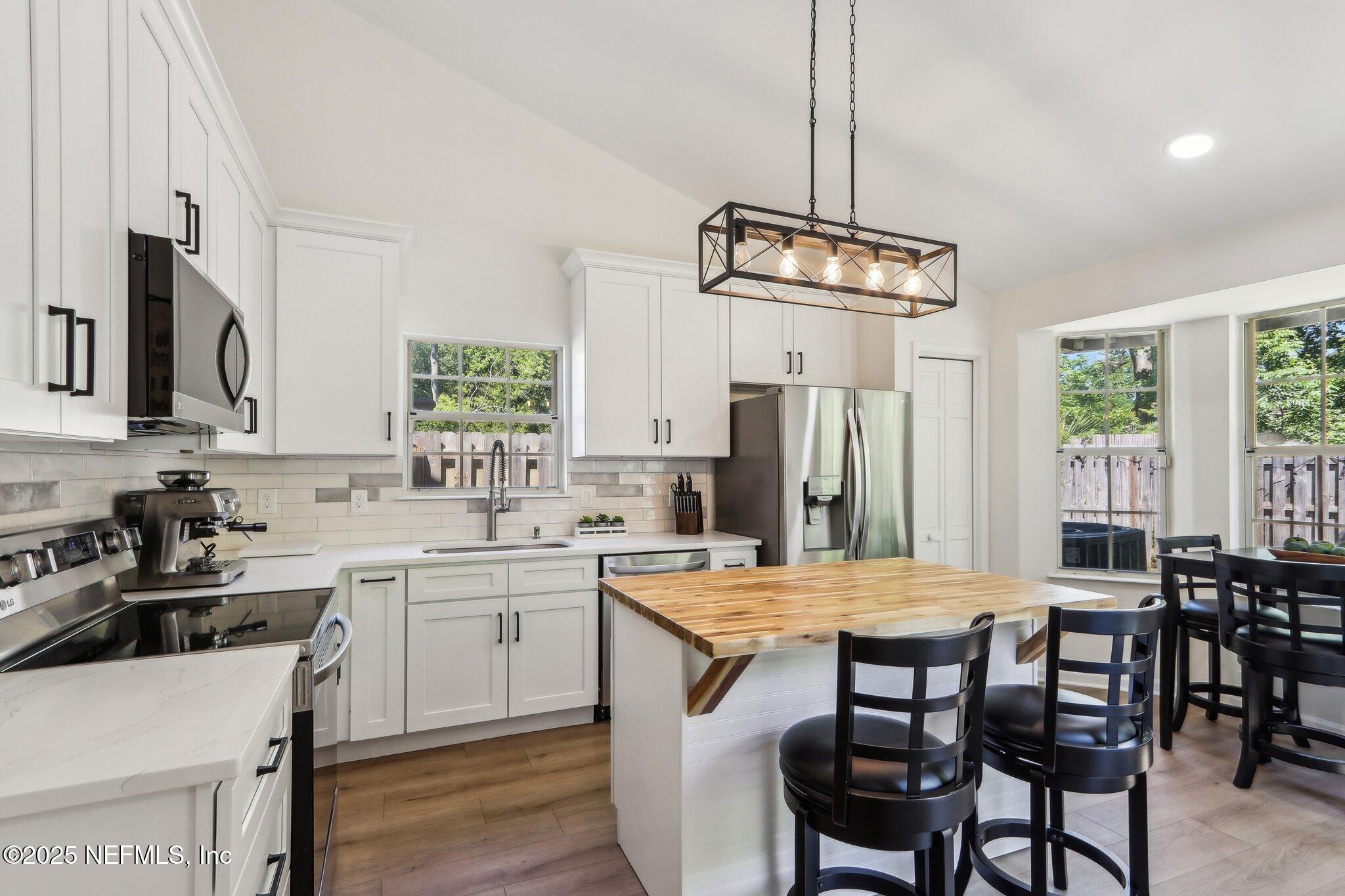 8727 Goodbys Trace Drive Jacksonville, FL 32217 - Photo 11 of 32 a kitchen with a table chairs stove and refrigerator