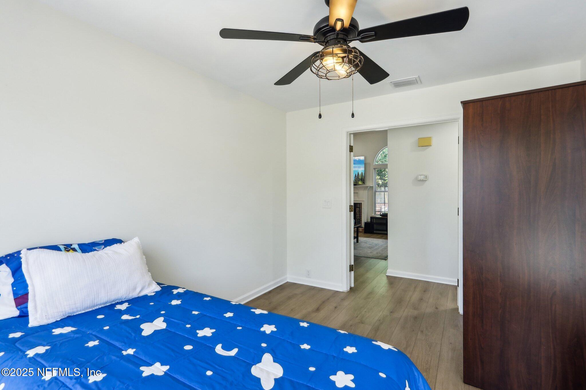 8727 Goodbys Trace Drive Jacksonville, FL 32217 - Photo 23 of 32 a bedroom with a bed and a chandelier fan