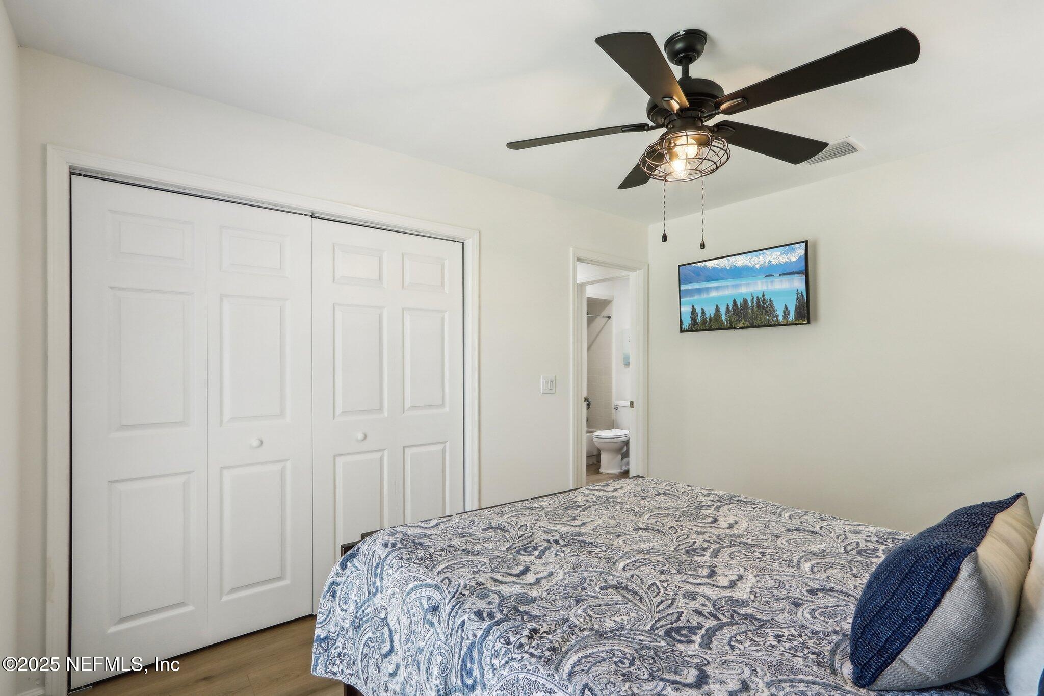 8727 Goodbys Trace Drive Jacksonville, FL 32217 - Photo 25 of 32 a bedroom with a bed and a chandelier
