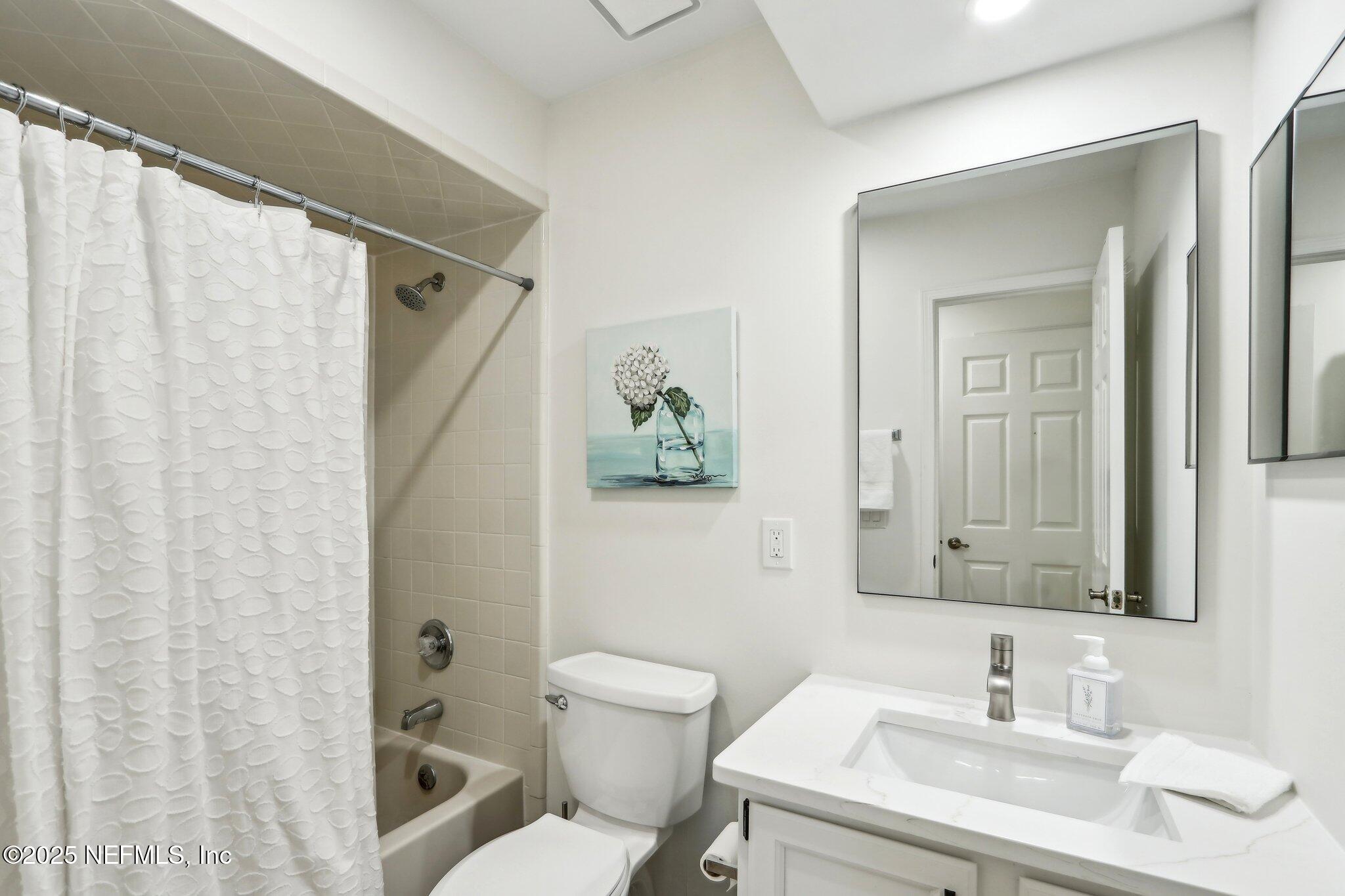 8727 Goodbys Trace Drive Jacksonville, FL 32217 - Photo 26 of 32 a bathroom with a sink a toilet and shower curtain