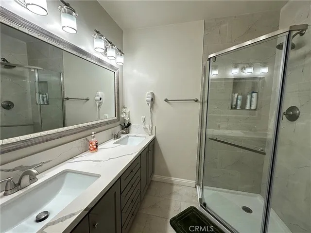 a bathroom with a shower sink vanity and mirror