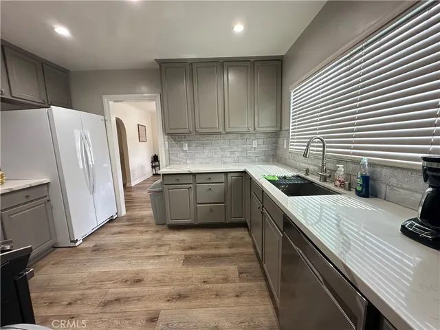 a kitchen with a sink a refrigerator and cabinets