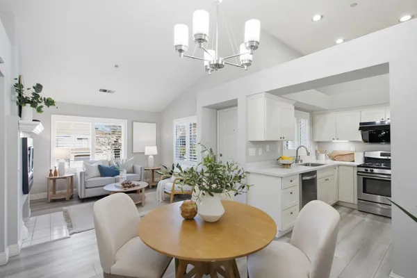 a view of a dining room with furniture a kitchen and chandelier