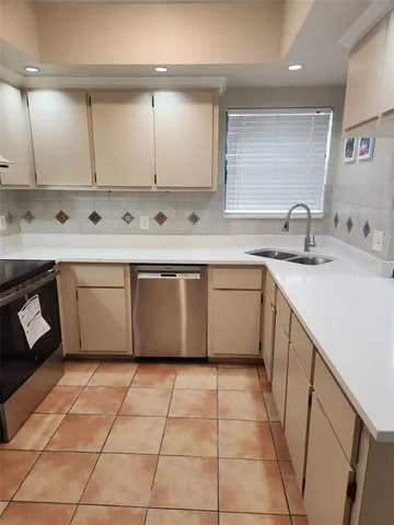 a kitchen with a sink a stove and cabinets