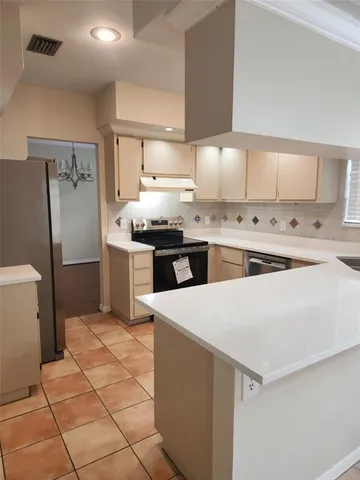 a kitchen with stainless steel appliances a stove a sink and a refrigerator