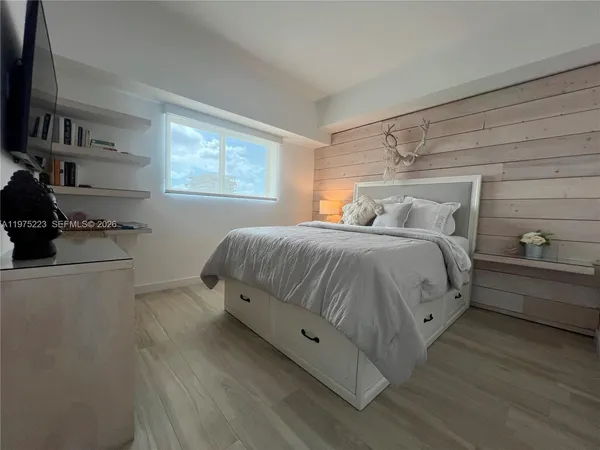 a bed sitting in a bedroom next to a window