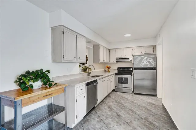 a kitchen with white cabinets and white appliances