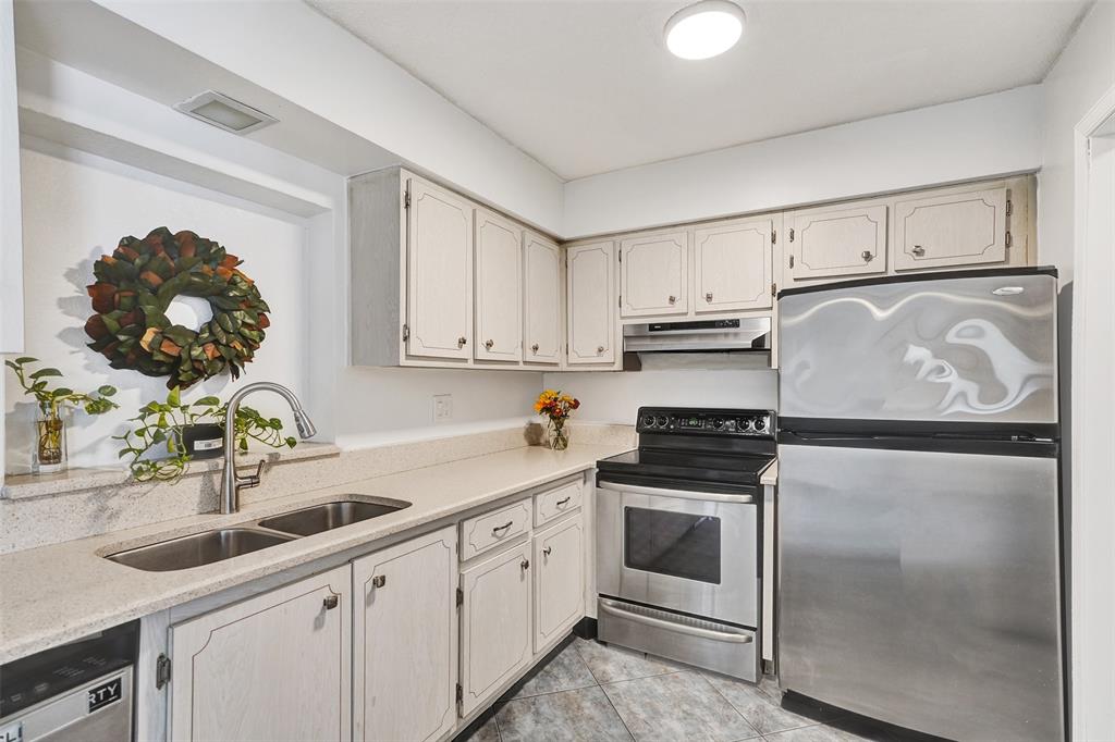 7003 Northwest 95th Terrace Tamarac, FL 33321 - Photo 14 of 44 a kitchen with white cabinets and white appliances