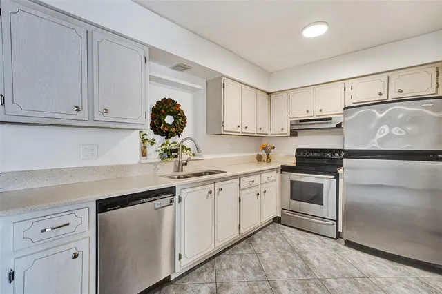 a kitchen with white cabinets and white appliances