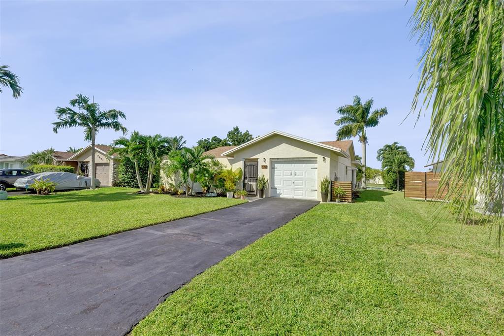 7003 Northwest 95th Terrace Tamarac, FL 33321 - Photo 2 of 44 a front view of a house with a yard and garage