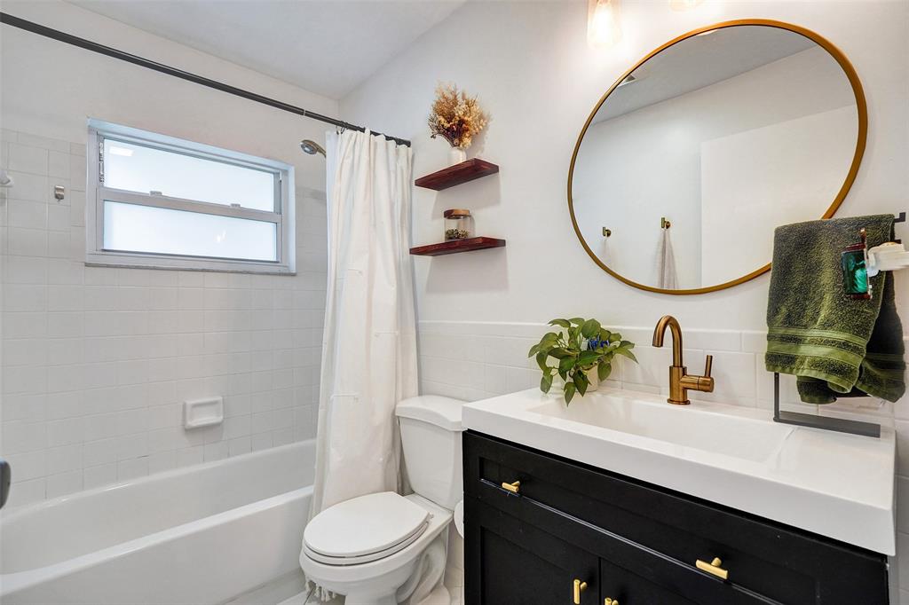 7003 Northwest 95th Terrace Tamarac, FL 33321 - Photo 27 of 44 a bathroom with a sink a mirror a toilet and a mirror