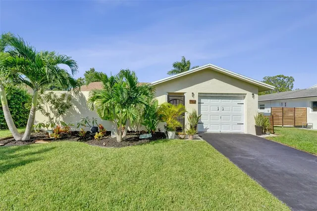 a front view of a house with a yard and trees