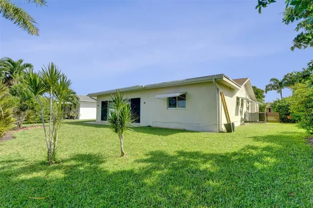 a view of a house with backyard and a tree