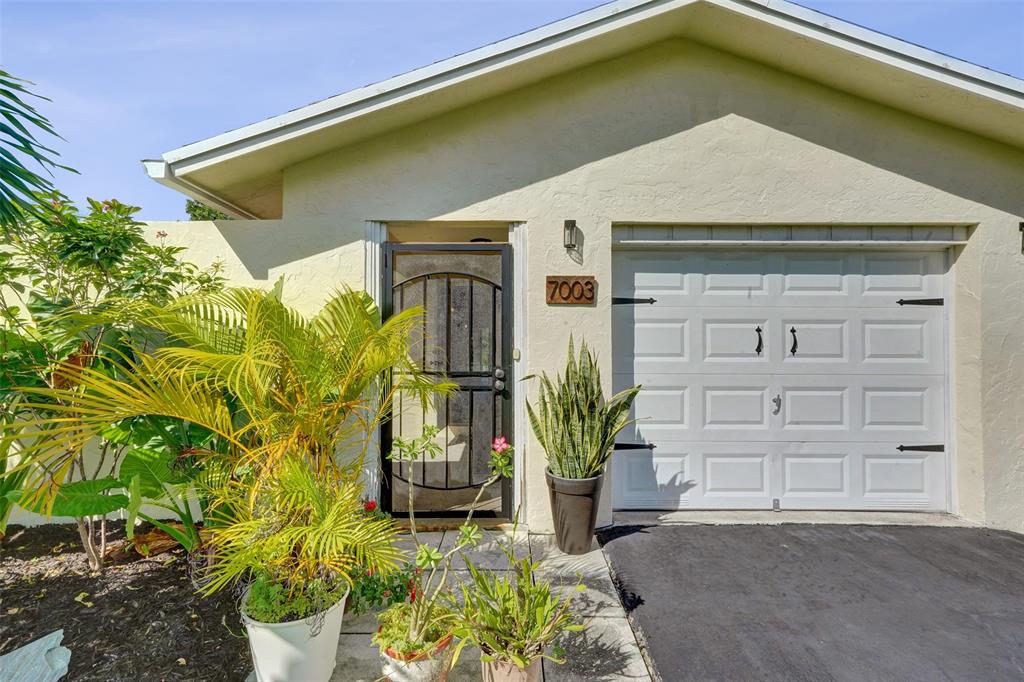 7003 Northwest 95th Terrace Tamarac, FL 33321 - Photo 5 of 44 a front view of a house with a yard
