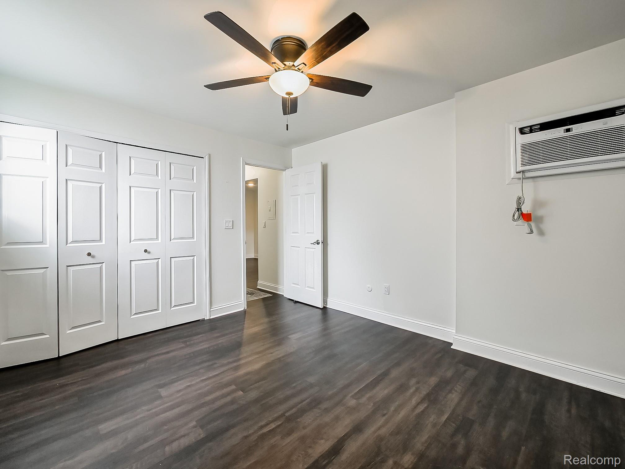4905 South Crooks Road Royal Oak, MI 48073 - Photo 17 of 28 Unfurnished bedroom with dark wood-style floors, ceiling fan, and a closet