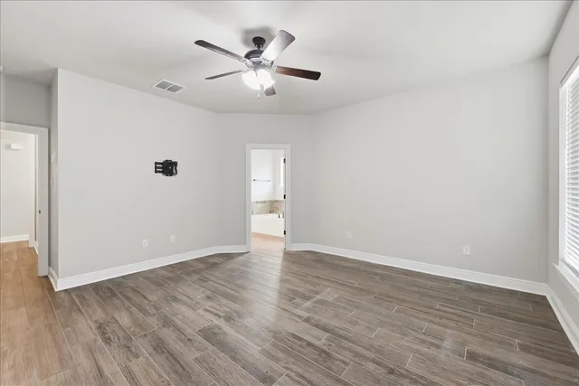 a view of an empty room with wooden floor