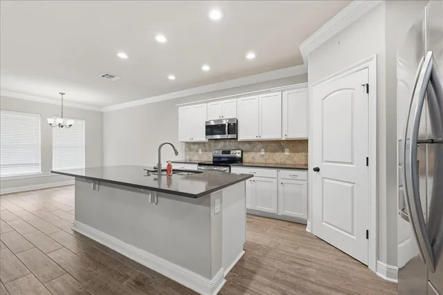 a kitchen with white cabinets and sink