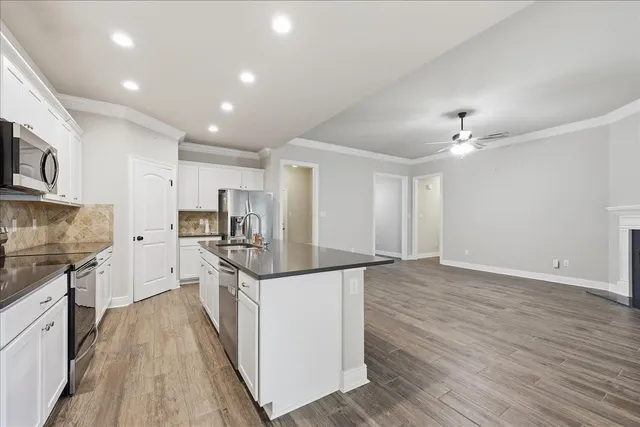 a kitchen with granite countertop a stove top oven and cabinets