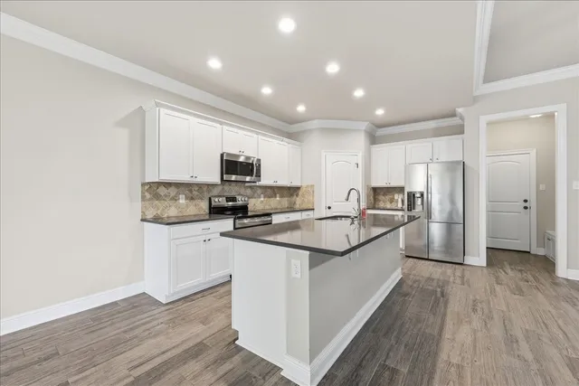 a large kitchen with stainless steel appliances lots of counter space and wooden floor