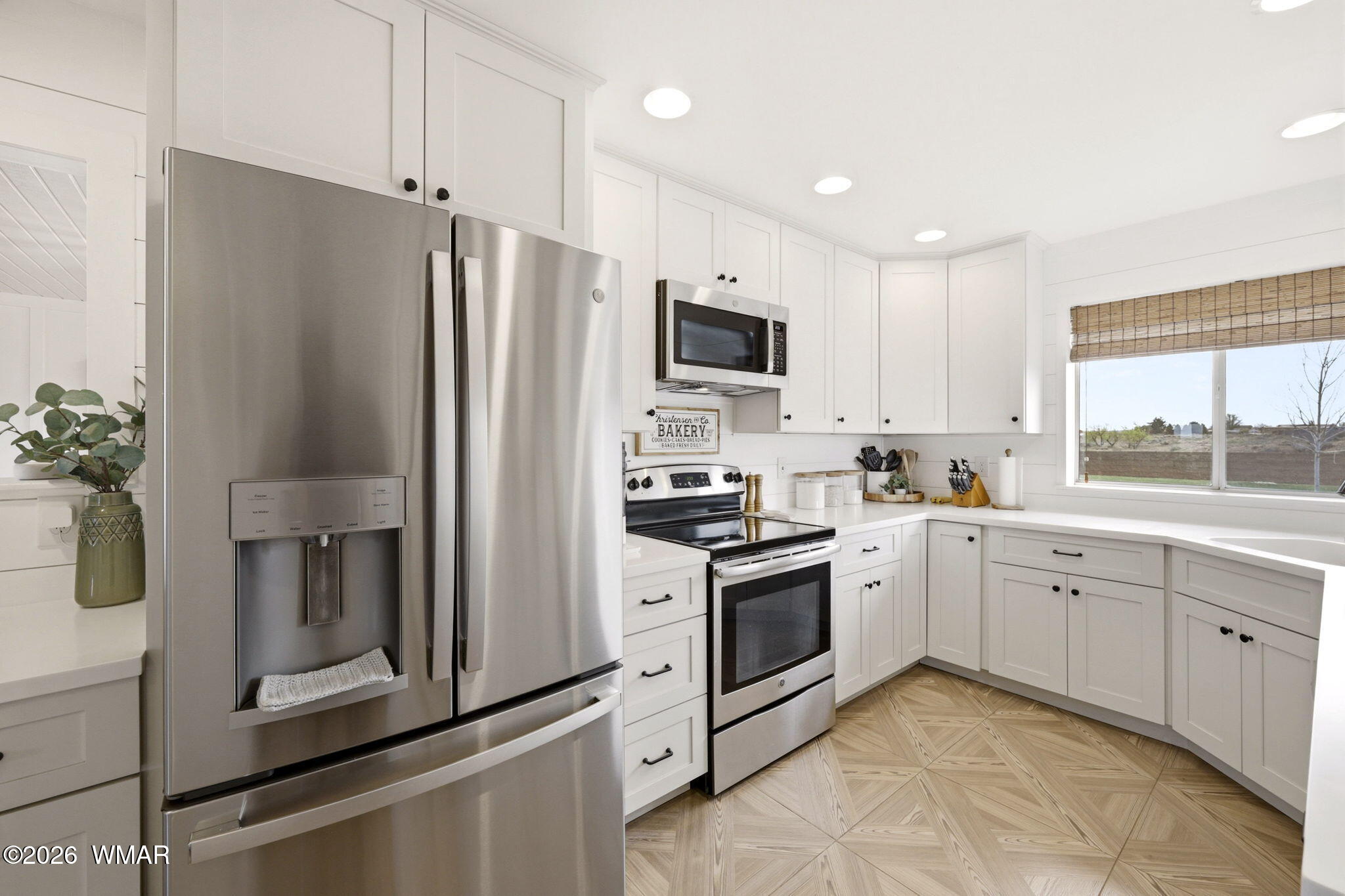 1491 Hunsaker Road Holbrook, AZ 86025 - Photo 12 of 40 a kitchen with white cabinets and stainless steel appliances