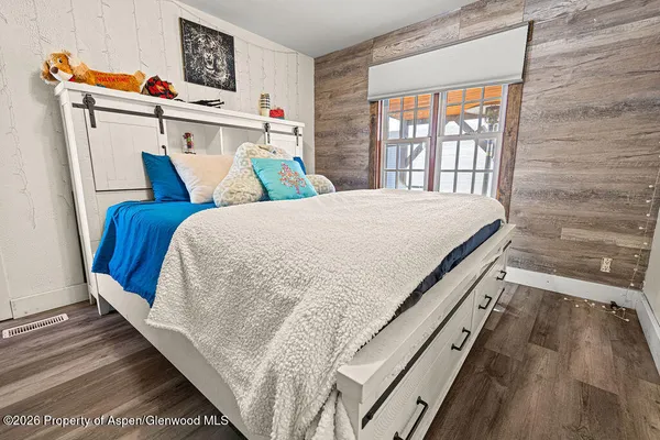 a bed sitting in a bedroom next to a window