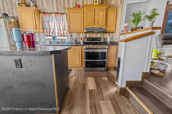 a kitchen with stainless steel appliances a stove a sink and a refrigerator