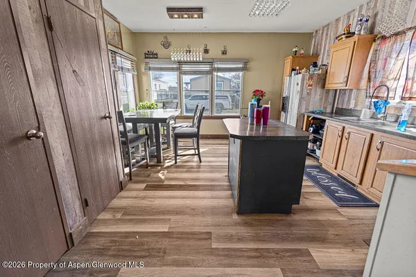 a dining room with wooden floor and large windows