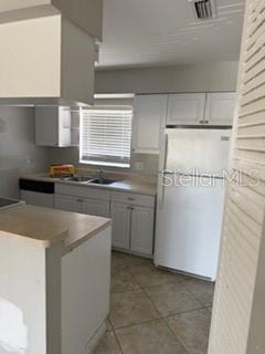 2744 Hidden Lake Boulevard, Unit C Sarasota, FL 34237 - Photo 5 of 6 a kitchen with a sink stove and cabinets