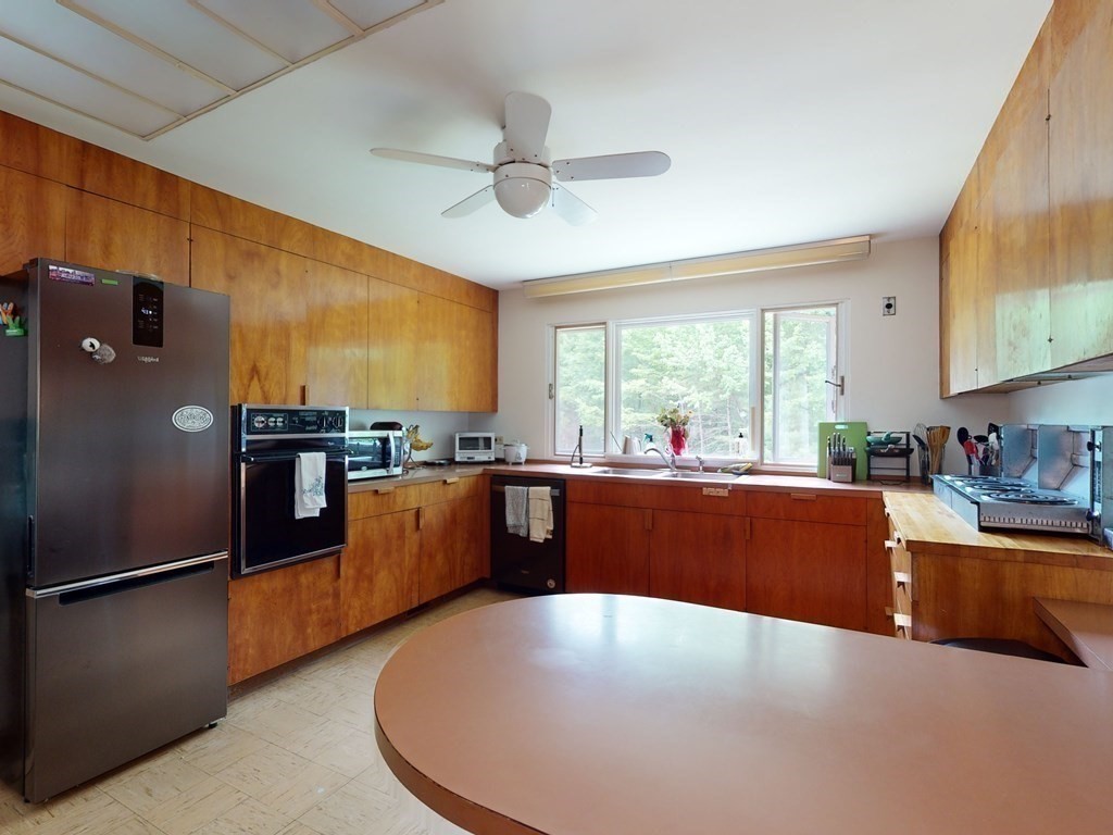 73 Bolton Road Harvard, MA 01451 - Photo 17 of 28 a large kitchen with kitchen island a large counter top space appliances and a ceiling fan