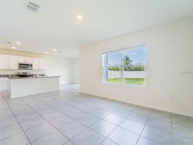 a view of kitchen with stainless steel appliances granite countertop a stove a sink and a refrigerator