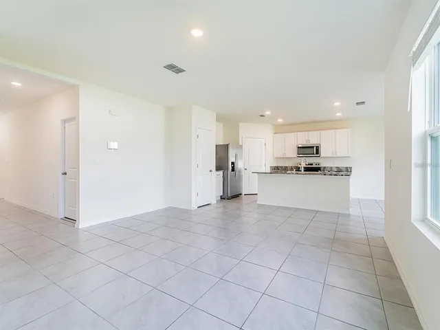 a view of kitchen with granite countertop cabinets and refrigerator