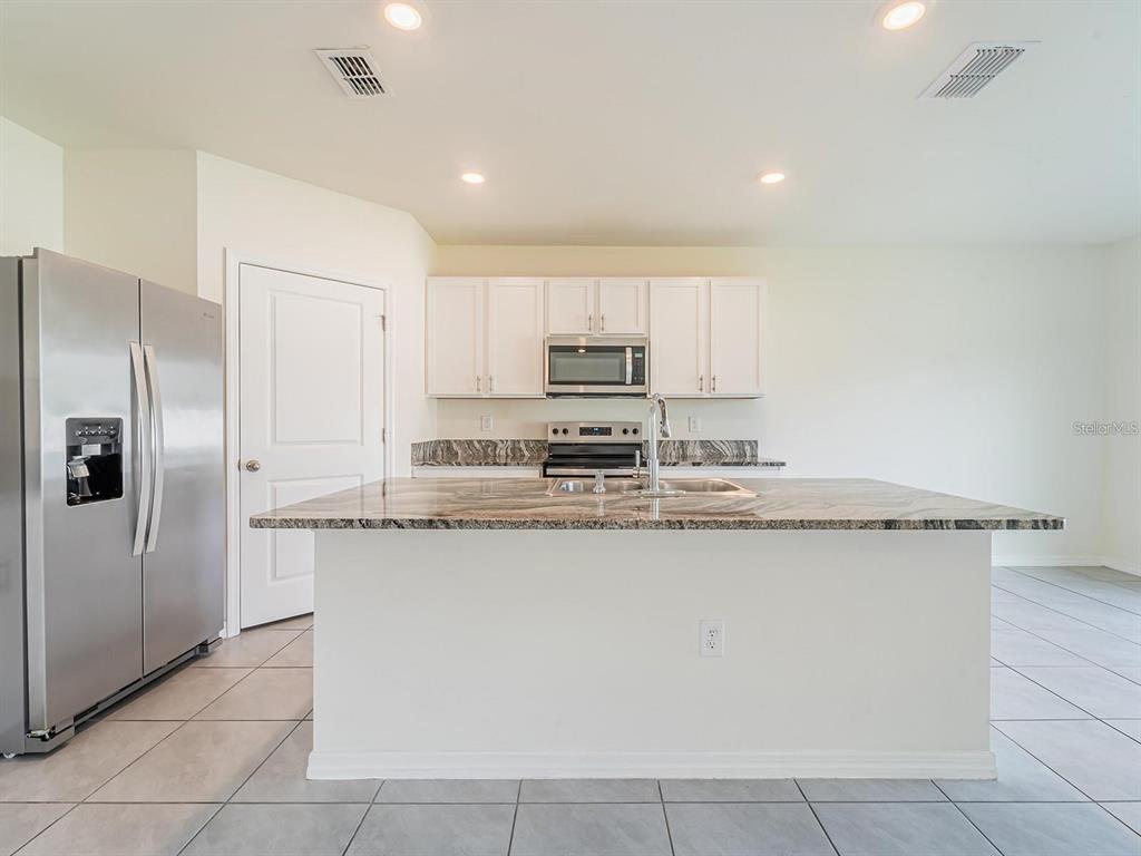 5510 Oxford Gray Road Wesley Chapel, FL 33545 - Photo 34 of 41 a kitchen with stainless steel appliances granite countertop a refrigerator and a stove