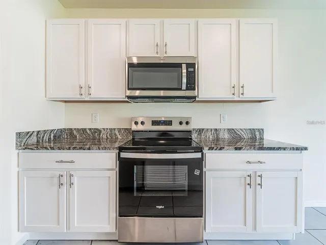 a kitchen with white cabinets and stainless steel appliances
