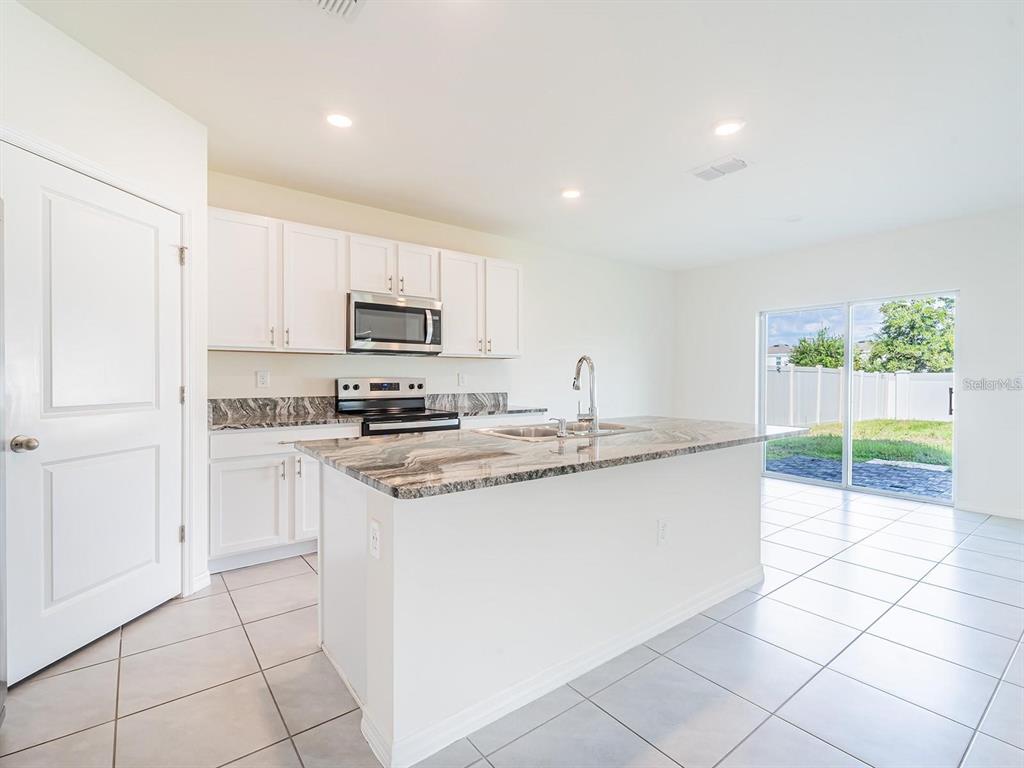 5510 Oxford Gray Road Wesley Chapel, FL 33545 - Photo 40 of 41 a kitchen with stainless steel appliances granite countertop a sink and a stove