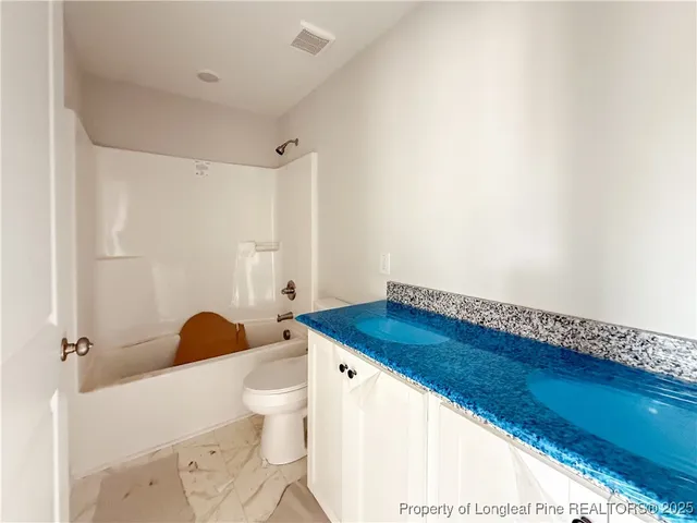 a bathroom with a sink a toilet and a shower