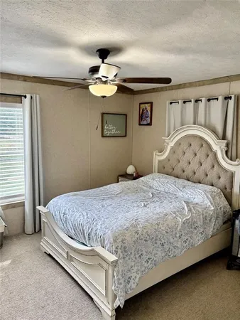 a bedroom with a bed and a ceiling fan