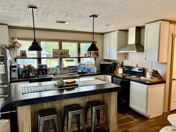 a kitchen with stainless steel appliances granite countertop a sink a stove and a wooden floors