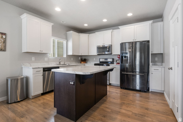 5155 East Rio Grande Way Eagle Mountain, UT 84005 - Photo 12 of 40 Kitchen with stainless steel appliances, dark wood-type flooring, recessed lighting, dual tone cabinetry, and a kitchen island