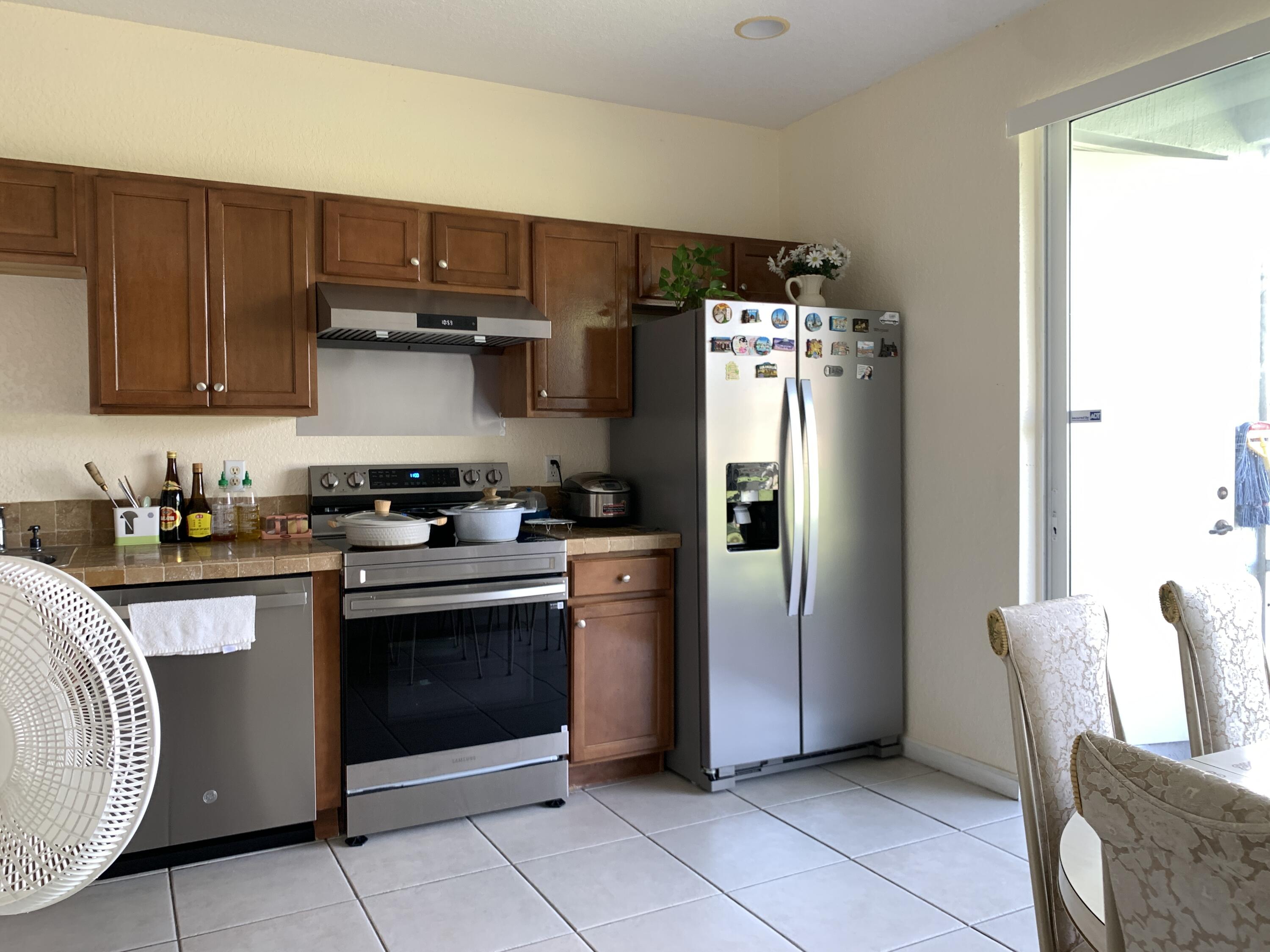 2304 Center Stone Lane Riviera Beach, FL 33404 - Photo 5 of 15 a kitchen with stainless steel appliances granite countertop a refrigerator and a stove top oven