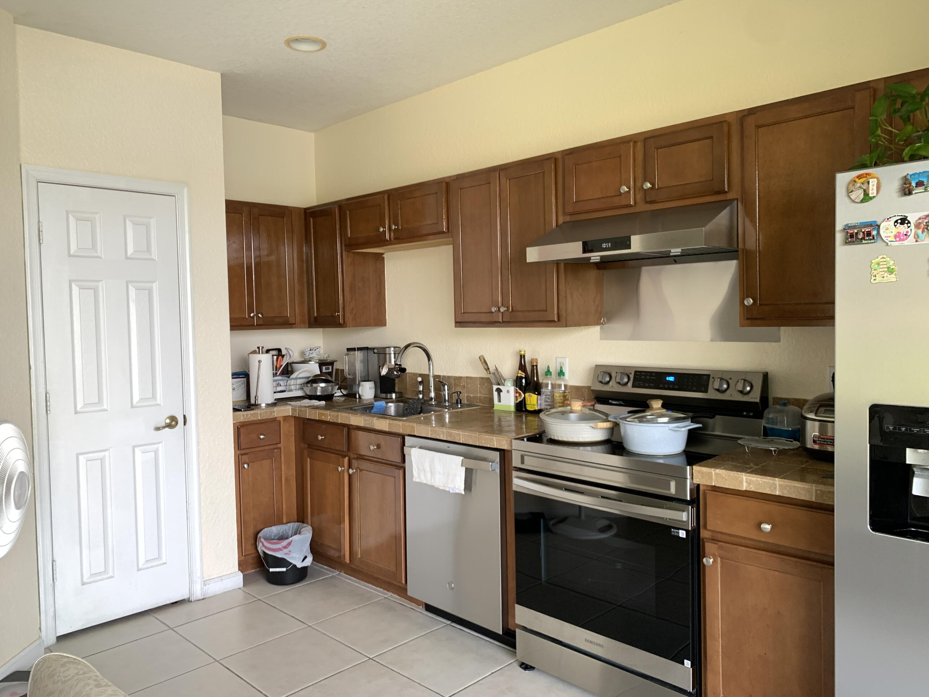 2304 Center Stone Lane Riviera Beach, FL 33404 - Photo 6 of 15 a kitchen with stainless steel appliances granite countertop a sink stove and cabinets