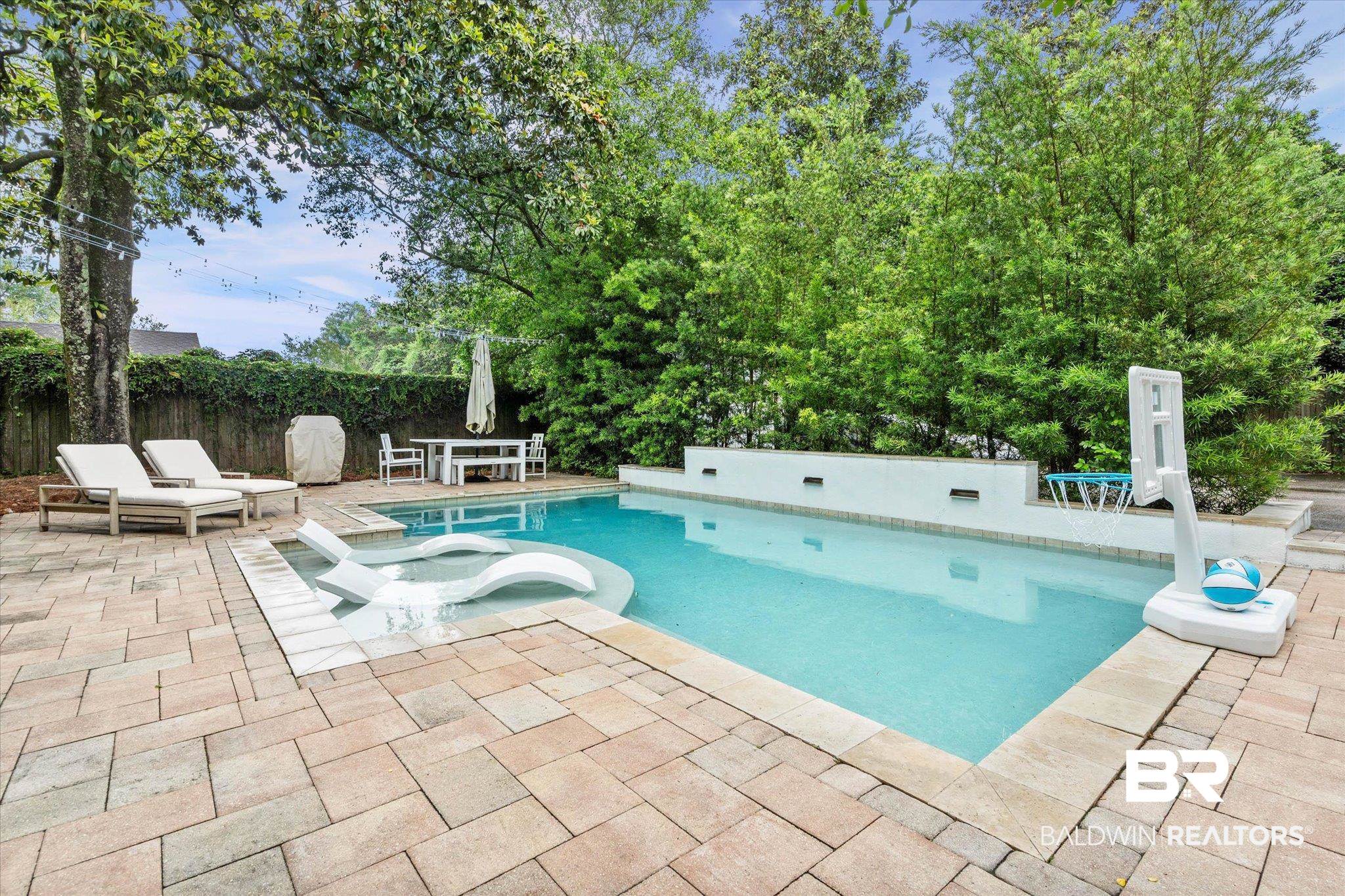 3863 Old Shell Road Mobile, AL 36608 - Photo 14 of 48 Inviting swimming pool with an integrated sun shelf, surrounded by a paver patio